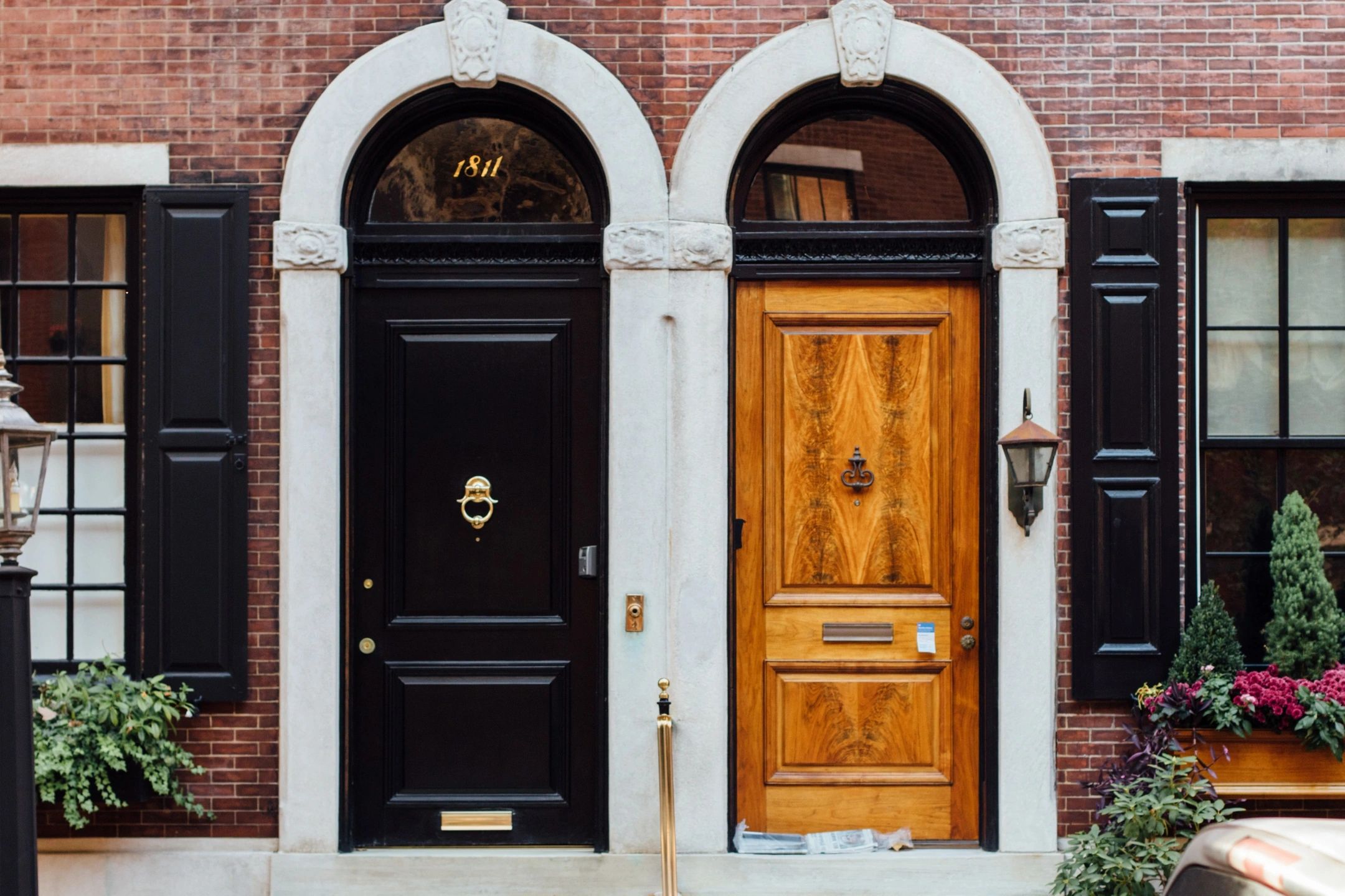 Two adjacent, arched wooden doors, brick facade.